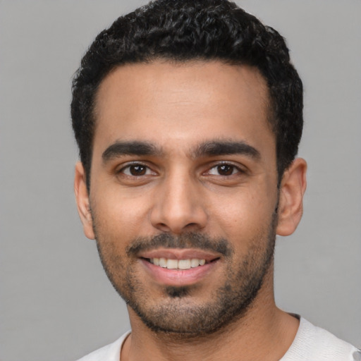 Joyful latino young-adult male with short  black hair and brown eyes