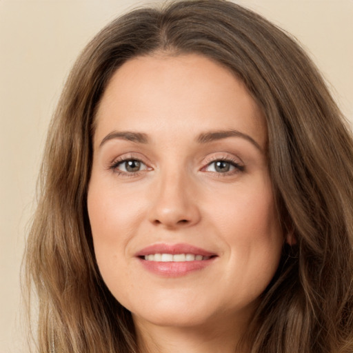 Joyful white young-adult female with long  brown hair and green eyes