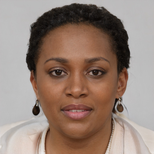 Joyful black young-adult female with short  brown hair and brown eyes
