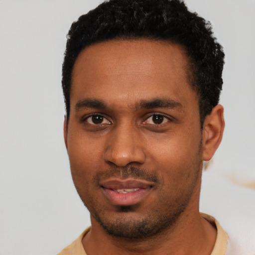 Joyful black young-adult male with short  black hair and brown eyes