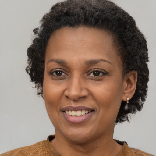 Joyful black adult female with short  brown hair and brown eyes