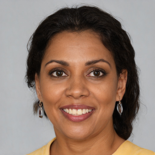 Joyful black adult female with medium  brown hair and brown eyes