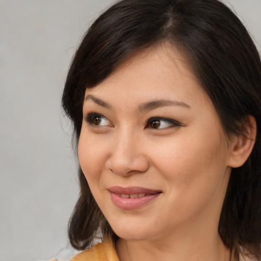 Joyful asian young-adult female with long  brown hair and brown eyes
