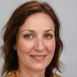 Joyful white adult female with medium  brown hair and blue eyes