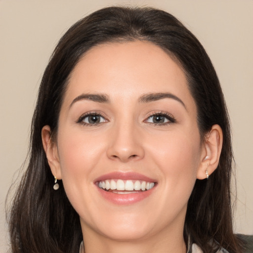 Joyful white young-adult female with long  brown hair and brown eyes