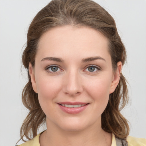 Joyful white young-adult female with medium  brown hair and grey eyes