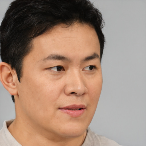 Neutral asian adult male with short  brown hair and brown eyes