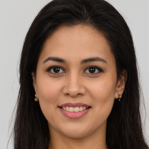 Joyful latino young-adult female with long  brown hair and brown eyes