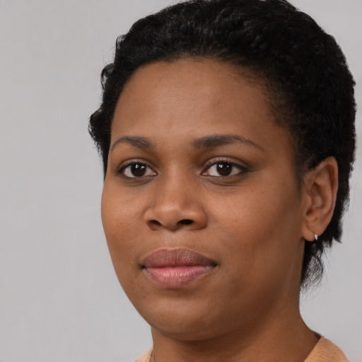 Joyful black young-adult female with short  black hair and brown eyes