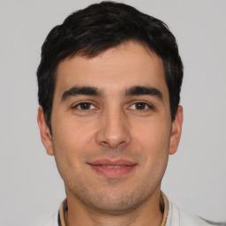 Joyful white young-adult male with short  black hair and brown eyes