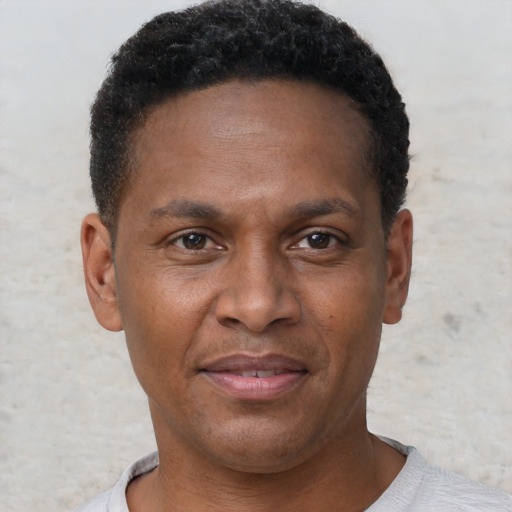 Joyful black adult male with short  brown hair and brown eyes