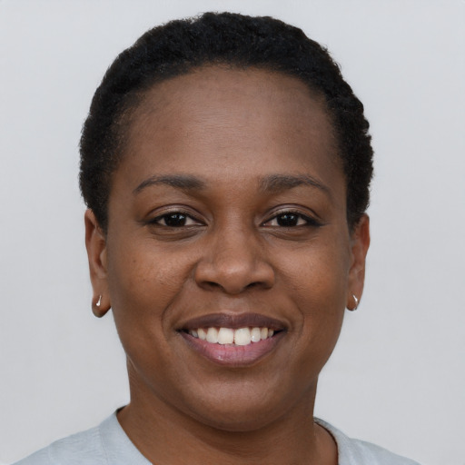 Joyful black young-adult female with short  black hair and brown eyes