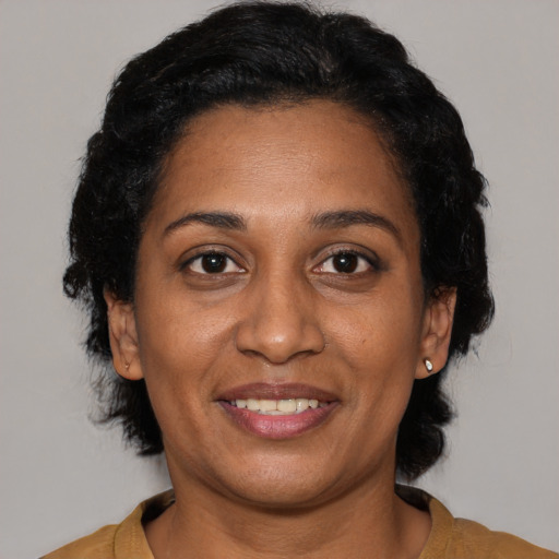 Joyful black adult female with short  black hair and brown eyes