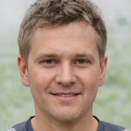 Joyful white adult male with short  brown hair and grey eyes