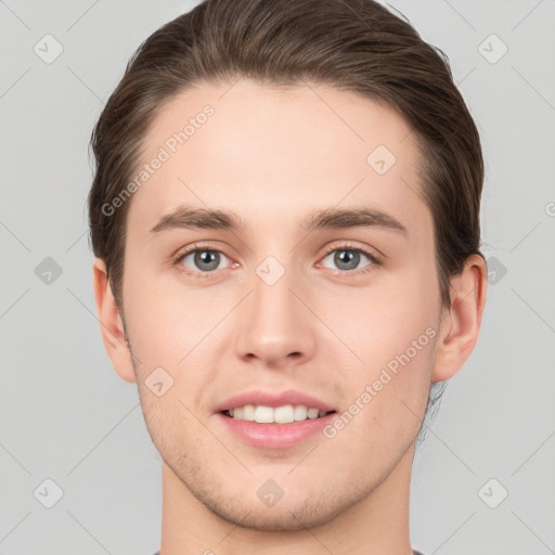 Joyful white young-adult male with short  brown hair and grey eyes