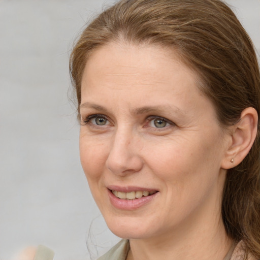 Joyful white adult female with medium  brown hair and grey eyes