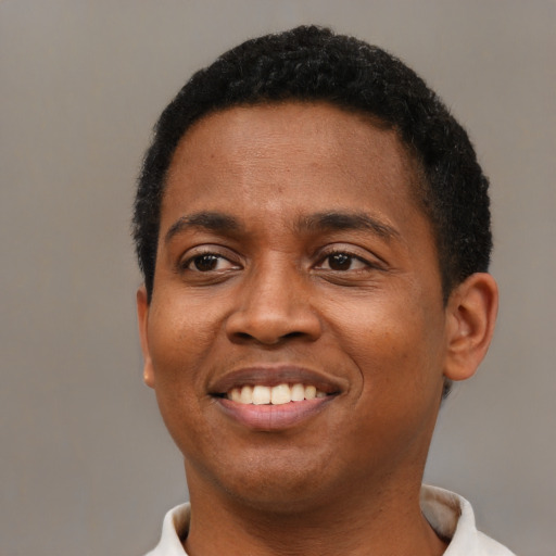 Joyful black young-adult male with short  brown hair and brown eyes