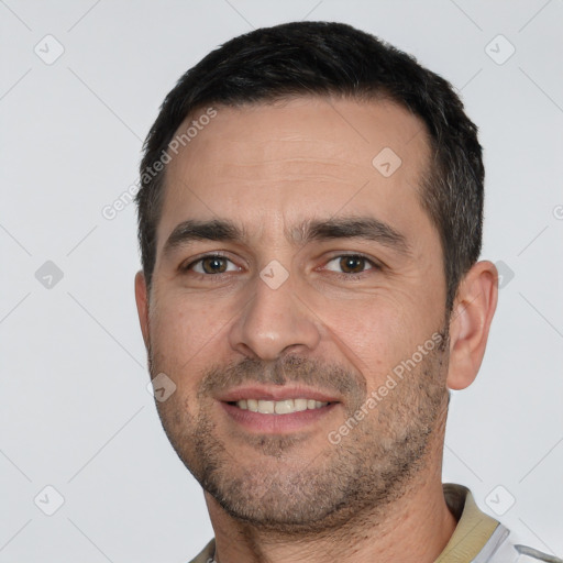 Joyful white adult male with short  black hair and brown eyes