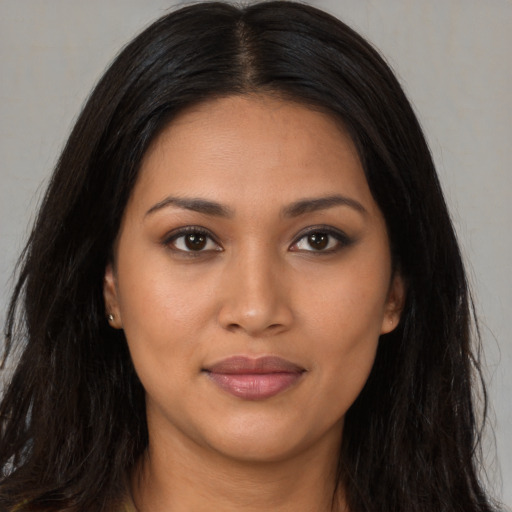 Joyful latino young-adult female with long  brown hair and brown eyes