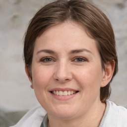 Joyful white young-adult female with medium  brown hair and grey eyes