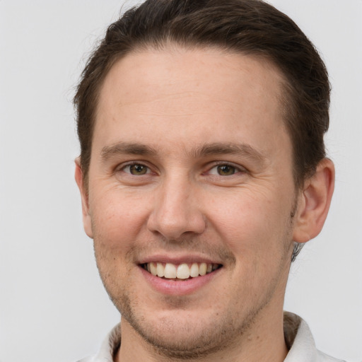 Joyful white adult male with short  brown hair and grey eyes