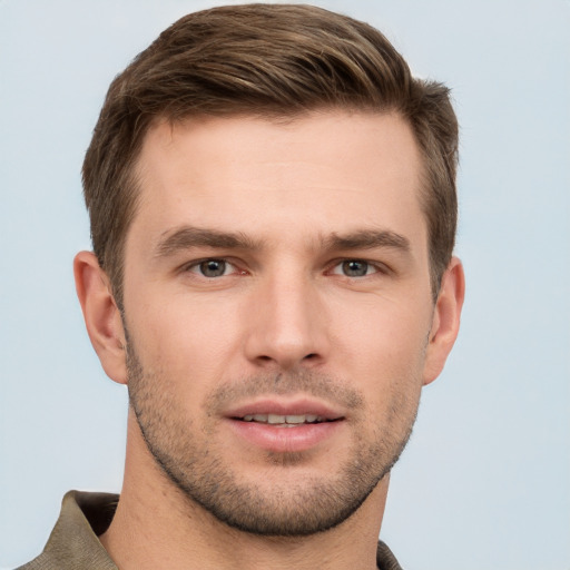 Joyful white young-adult male with short  brown hair and grey eyes