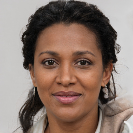 Joyful latino adult female with medium  brown hair and brown eyes
