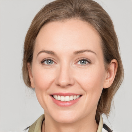 Joyful white young-adult female with medium  brown hair and grey eyes