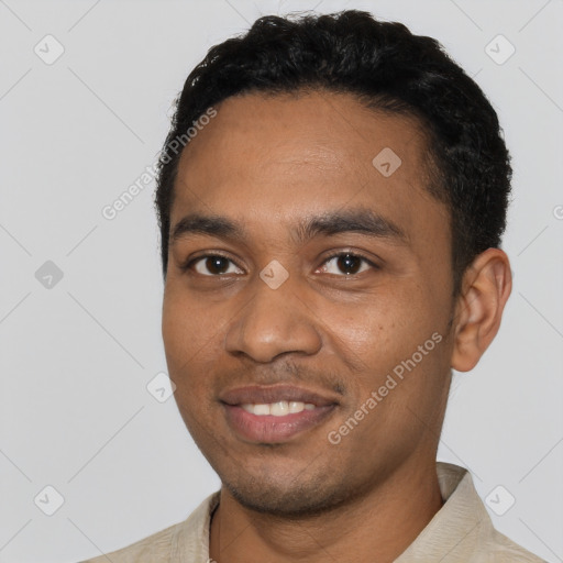 Joyful black young-adult male with short  black hair and brown eyes