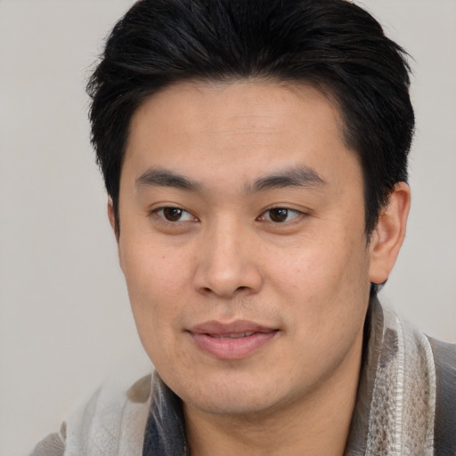 Joyful asian young-adult male with short  black hair and brown eyes