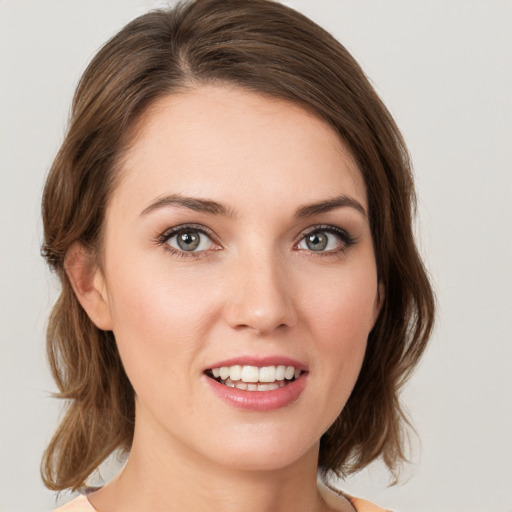 Joyful white young-adult female with medium  brown hair and green eyes