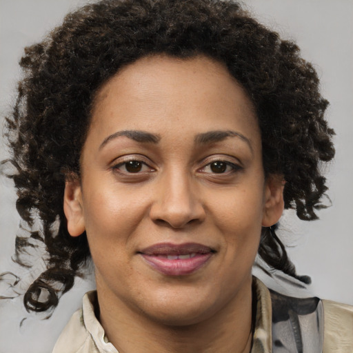 Joyful black adult female with medium  brown hair and brown eyes