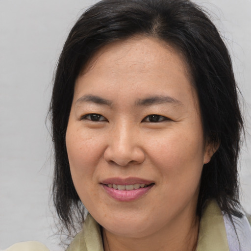 Joyful asian adult female with medium  brown hair and brown eyes