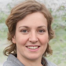 Joyful white young-adult female with medium  brown hair and blue eyes