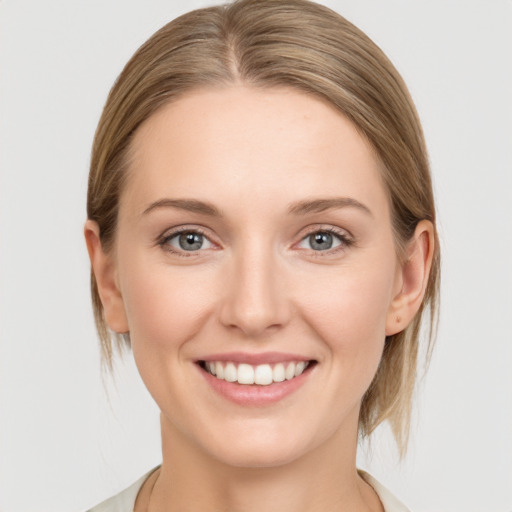 Joyful white young-adult female with medium  brown hair and grey eyes