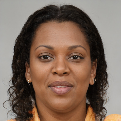 Joyful black adult female with medium  brown hair and brown eyes