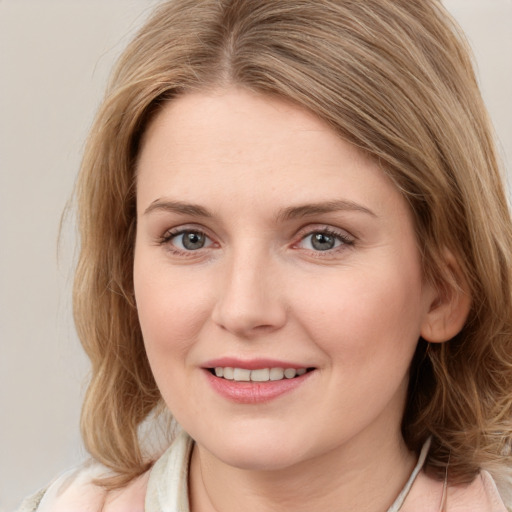 Joyful white young-adult female with medium  brown hair and blue eyes