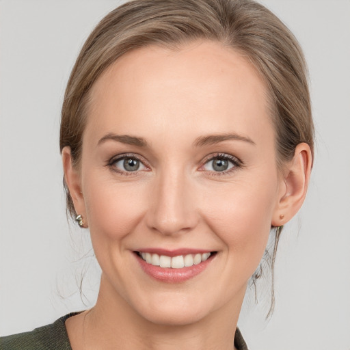 Joyful white young-adult female with medium  brown hair and grey eyes