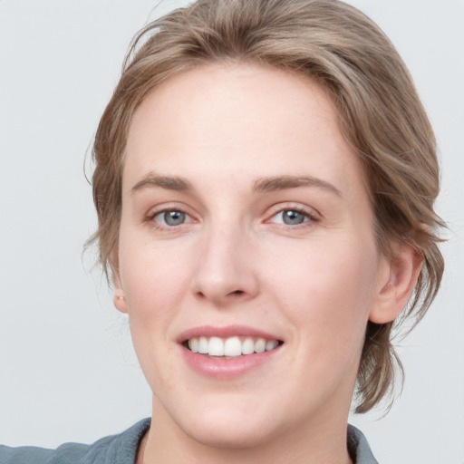 Joyful white young-adult female with medium  brown hair and blue eyes