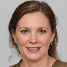 Joyful white adult female with medium  brown hair and grey eyes