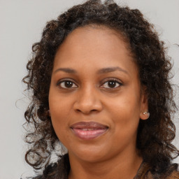 Joyful black adult female with long  brown hair and brown eyes