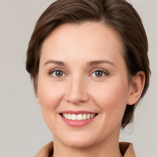 Joyful white young-adult female with medium  brown hair and green eyes