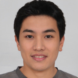 Joyful asian young-adult male with short  black hair and brown eyes