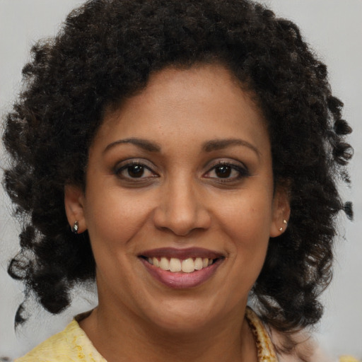 Joyful black young-adult female with medium  brown hair and brown eyes