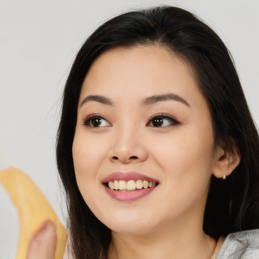 Joyful asian young-adult female with medium  black hair and brown eyes