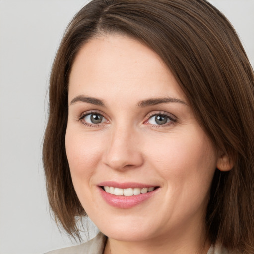 Joyful white young-adult female with medium  brown hair and grey eyes