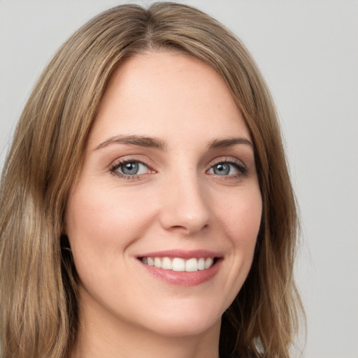 Joyful white young-adult female with long  brown hair and green eyes