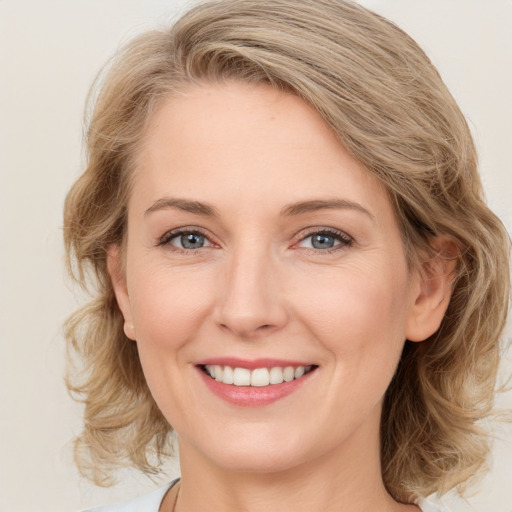 Joyful white young-adult female with medium  brown hair and blue eyes