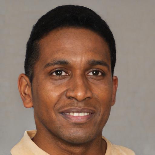 Joyful black young-adult male with short  black hair and brown eyes
