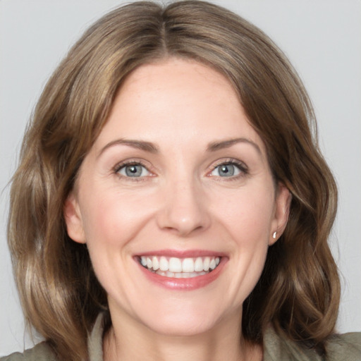 Joyful white adult female with medium  brown hair and grey eyes